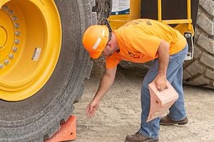 Stoneco employee remoing wheel block